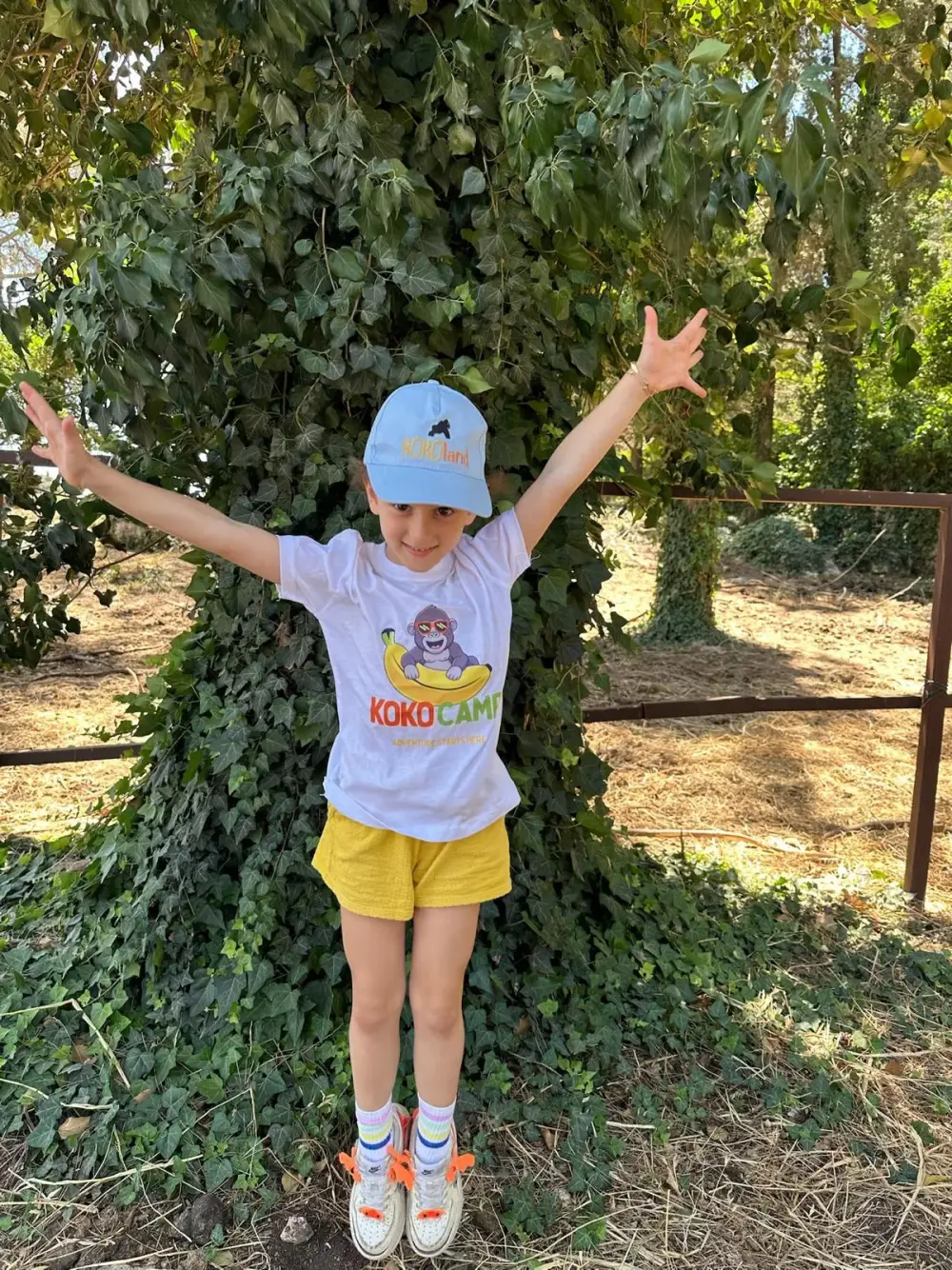 A girl jumping for joy in the KokoCamp woods
