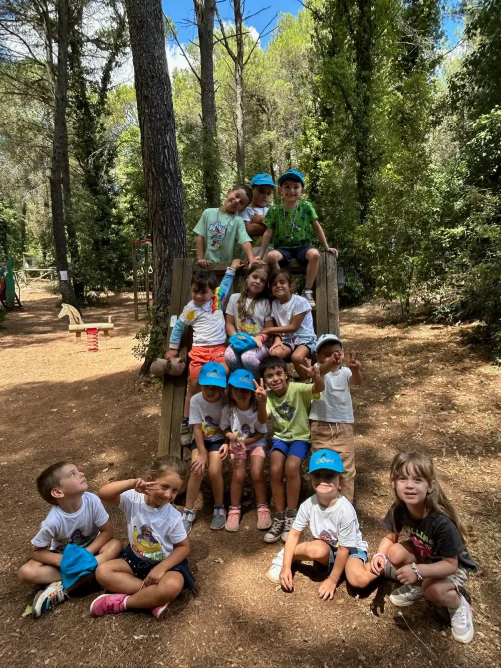 Children sitting on a log at KokoCamp
