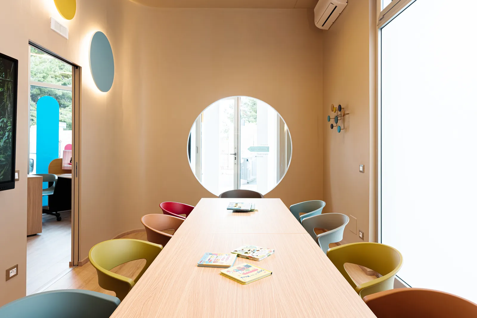A classroom at the KOKOland school in Monopoli, with the round window and colourful chairs
