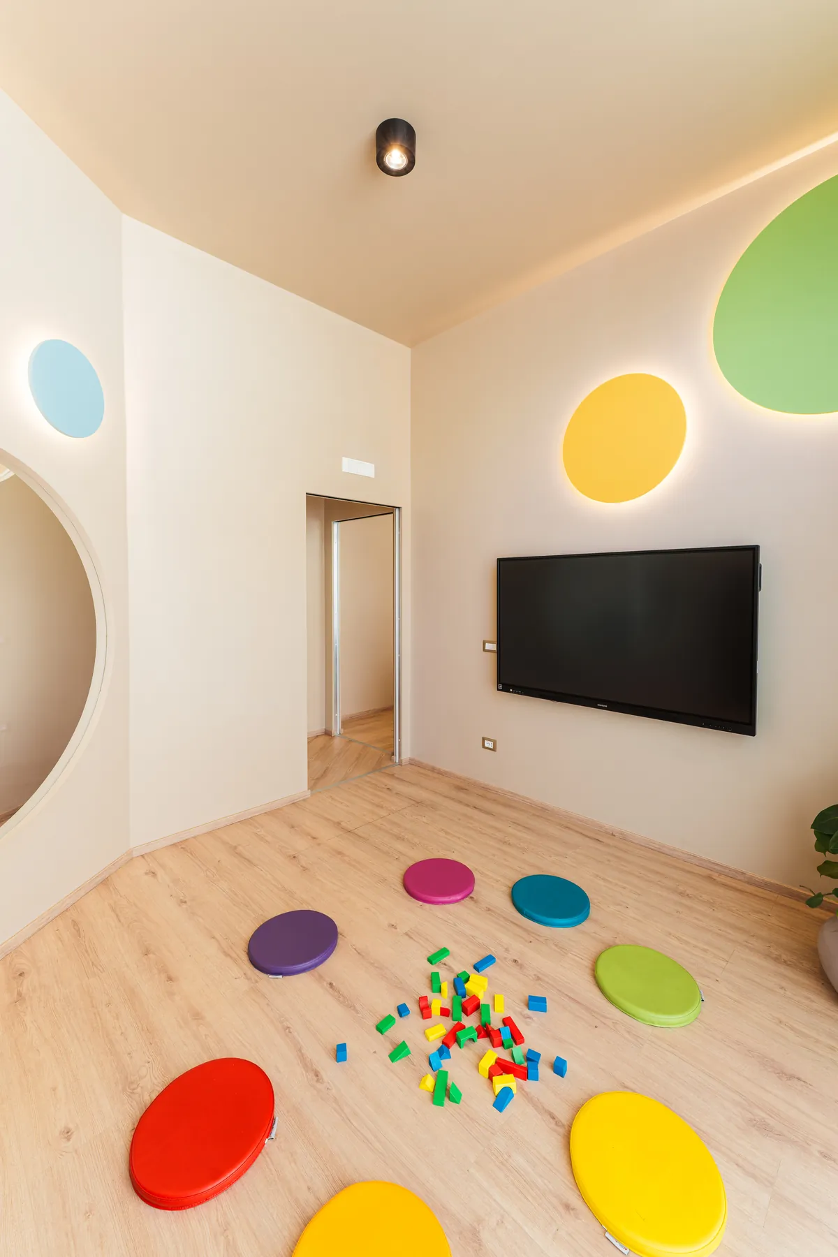 Colourful cushions and building bricks on the wooden floor of a KOKOland classroom in Monopoli