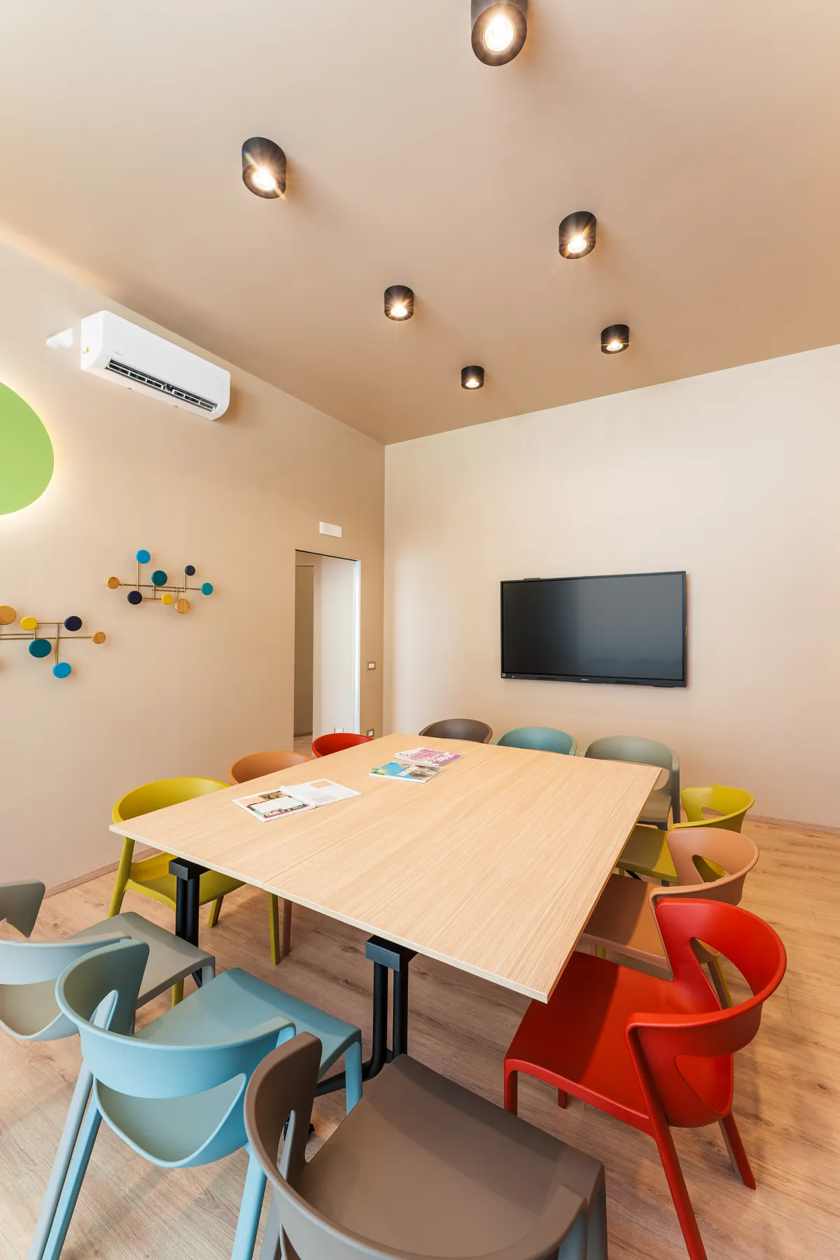 Blue, red and yellow chairs around the table in a KOKOland classroom in Monopoli