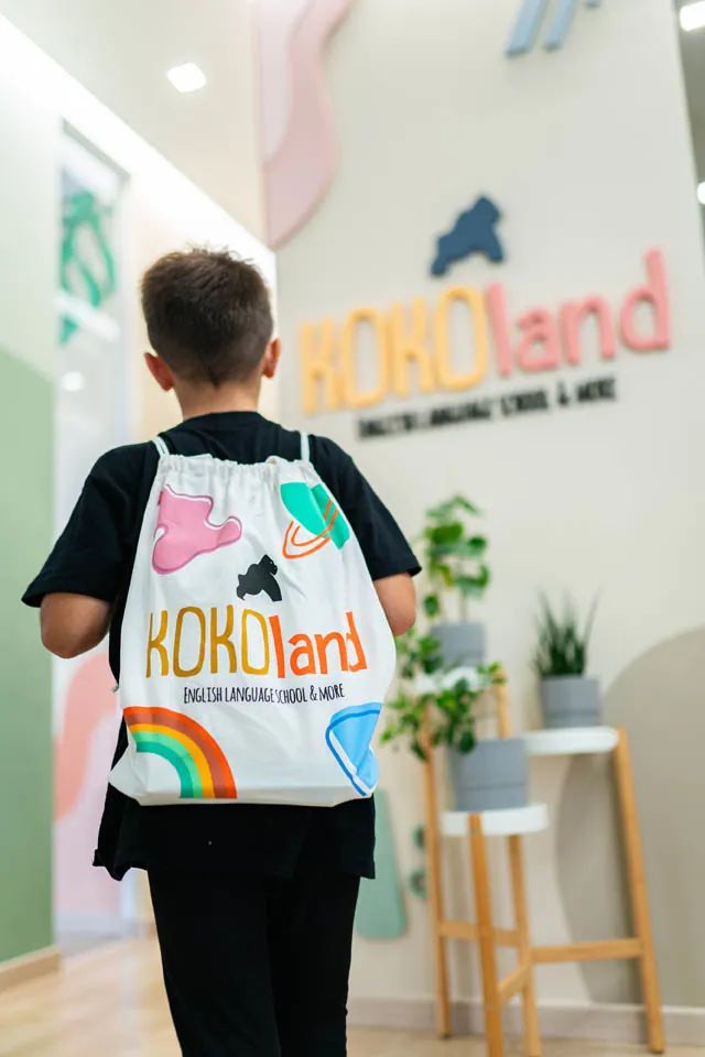A child seen from behind wearing a KOKOland backpack in the school entrance
